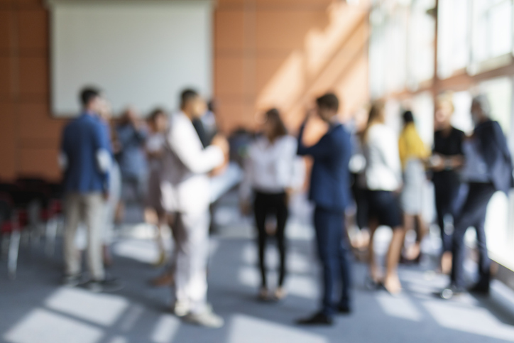 A blurred image of a group of business people attending a meeting