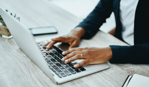 Hands typing on laptop