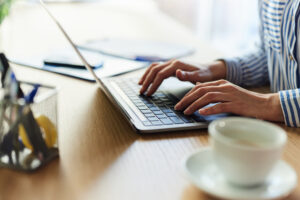 Hands typing on laptop