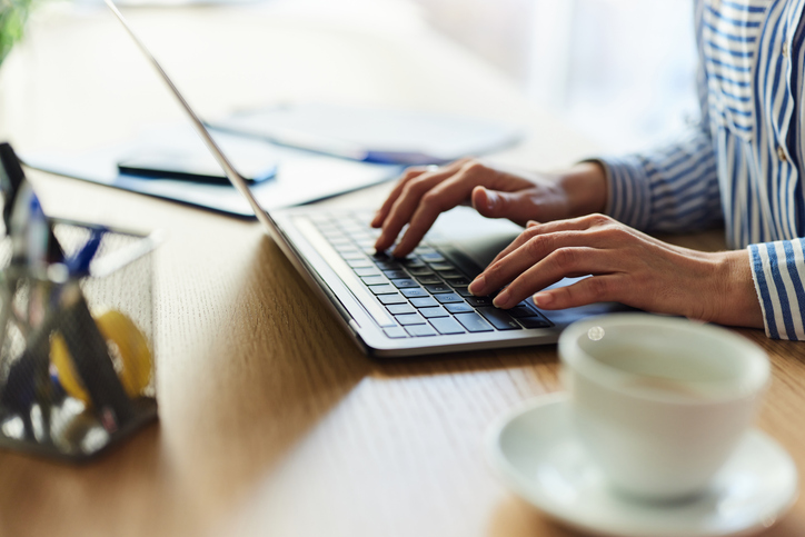 Hands typing on laptop